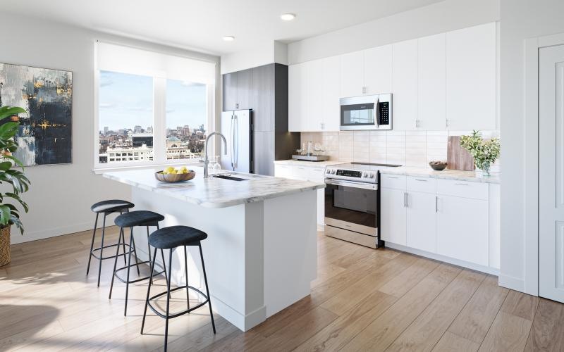 a kitchen with a large island with stools and a sink a fridge and stovetop