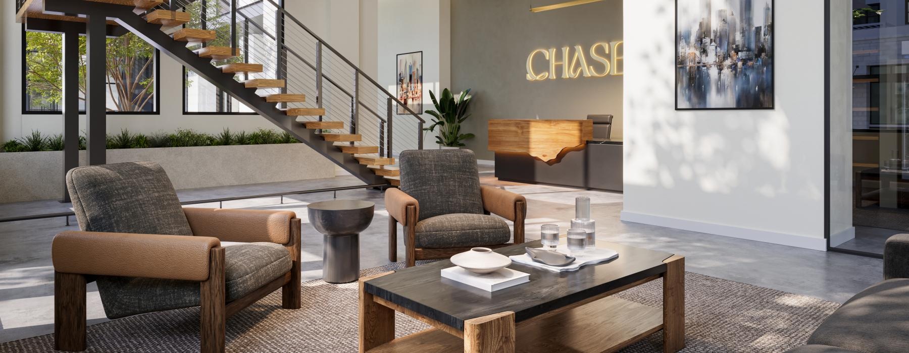 a lobby with a staircase and chairs with a table and many windows
