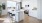 a kitchen with a large island with stools and a sink a fridge and stovetop