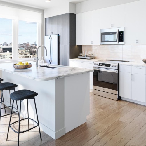 a kitchen with a large island with stools and a sink a fridge and stovetop